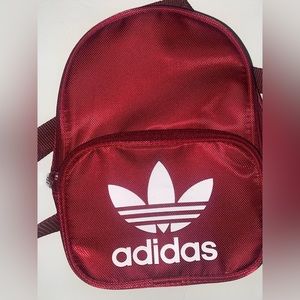 Burgundy Adidas mini backpack.